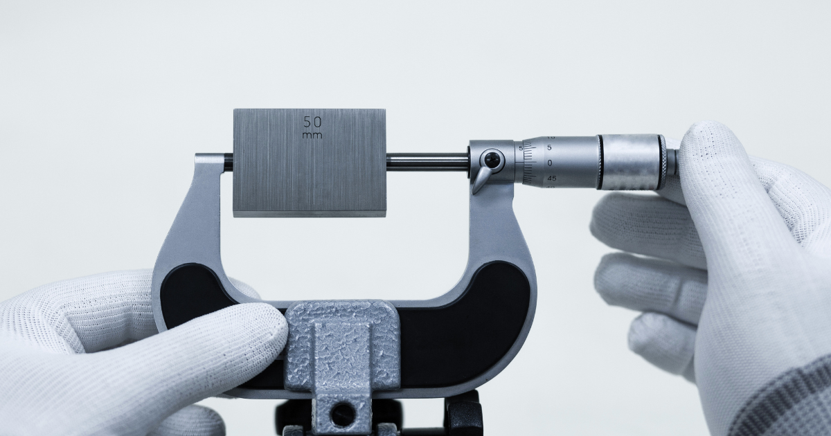 A hand holding a measuring instrument with 50mm measurement in it to highlight what is in our blog,