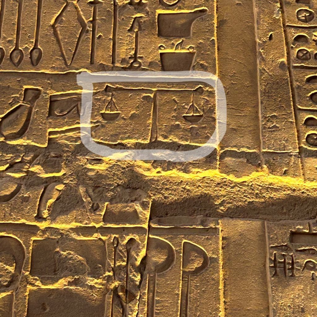 An image of an ancient Egyptian scene at the Temple of Kom Ombo in Awan, Egypt depicting some ancient weighing scales for weighing out medicines.