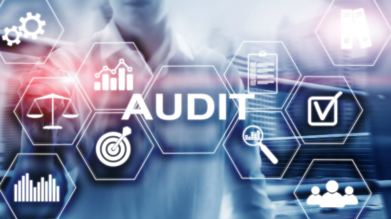 Some machinery on a blue background overlaid with the word audit.